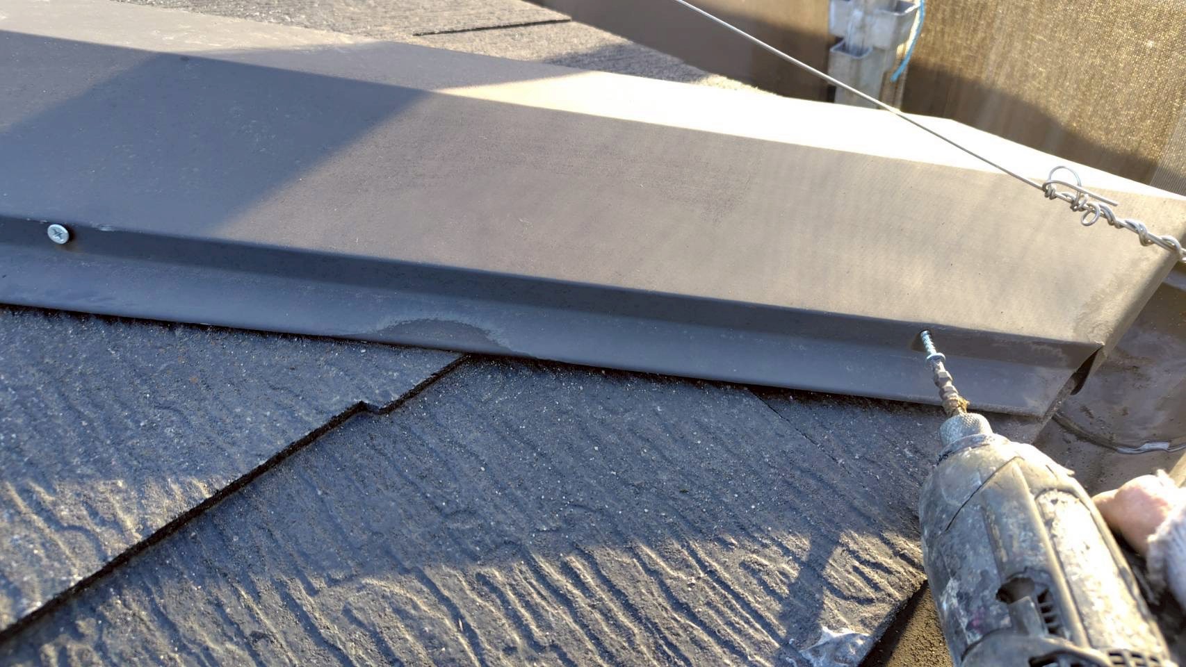 棟板金をビスで再固定中